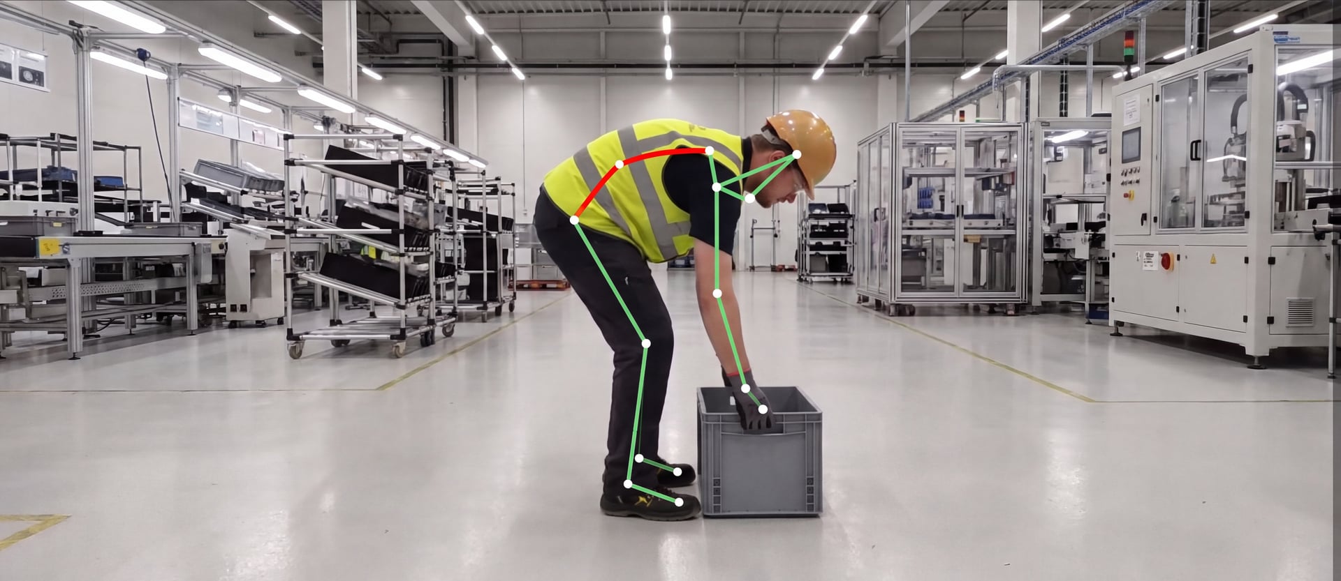 Phone-camera frame of a worker in full PPE lifting a crate, with the pose-estimation skeleton rendered on the body
